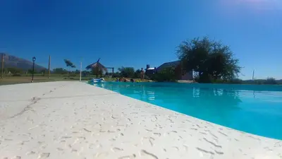 a view of a swimming pool with blue water at Cabañas Colibri in Las Rabonas