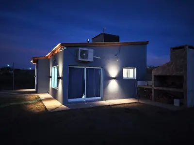 a house lit up at night with a window at Altura serrana in Villa Yacanto