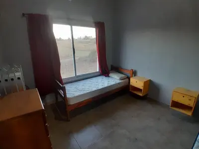 a small room with a window with a bed and a table at Altura serrana in Villa Yacanto