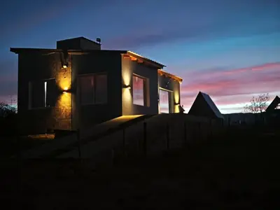 a house lit up at night with lights at Altura serrana in Villa Yacanto