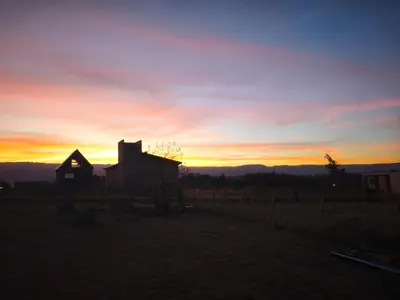 an old house in a field at sunset at Altura serrana in Villa Yacanto