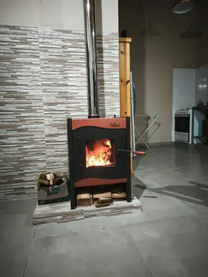 a stove in a room with a fire in it at Altura serrana in Villa Yacanto