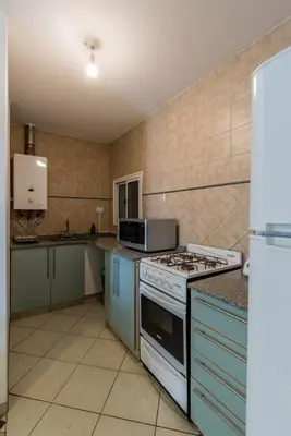 a kitchen with a stove and a microwave at Depto de confortables ambientes by Lofty in Cordoba
