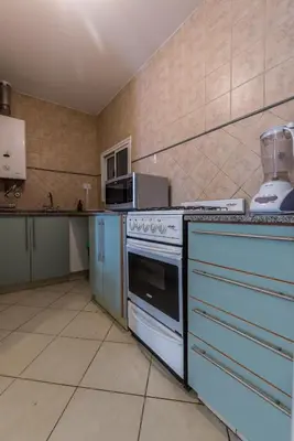 a kitchen with a white stove and a sink at Depto de confortables ambientes by Lofty in Cordoba