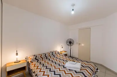 a bedroom with a bed and a desk and a fan at Depto de confortables ambientes by Lofty in Cordoba
