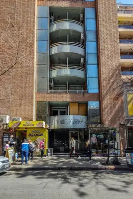 a tall building with people walking in front of it at Depto de confortables ambientes by Lofty in Cordoba