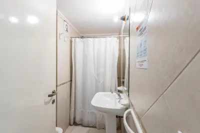 a white bathroom with a sink and a shower at Depto de confortables ambientes by Lofty in Cordoba