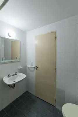 a bathroom with a sink and a toilet and a door at Departamento con balcón espectacular by Lofty in Cordoba