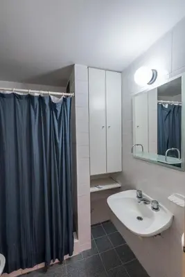 a bathroom with a sink and a shower curtain at Departamento con balcón espectacular by Lofty in Cordoba