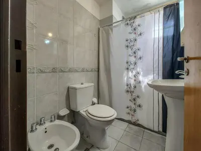 a white bathroom with a toilet and a sink at Alójate en la Docta by Lofty in Cordoba