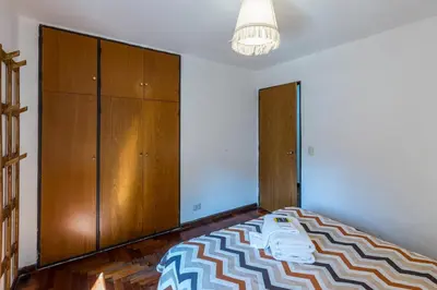 a bedroom with a bed and wooden cabinets at Alójate en la Docta by Lofty in Cordoba