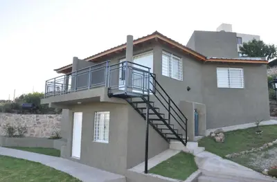 a house with a staircase on the side of it at Complejo Lamarca in Villa Carlos Paz