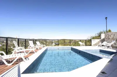 a swimming pool with chaise lounge chairs and a swimming pool at Complejo Lamarca in Villa Carlos Paz
