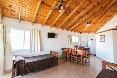 a room with a bed and a dining room with a table at Complejo Lamarca in Villa Carlos Paz