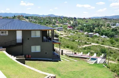a house on a hill with a view of a city at Complejo Lamarca in Villa Carlos Paz