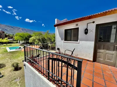 a house with a balcony with a door and a yard at Departamento con vista a las sierras en Planta Alta para 2 a 4 personas in Merlo