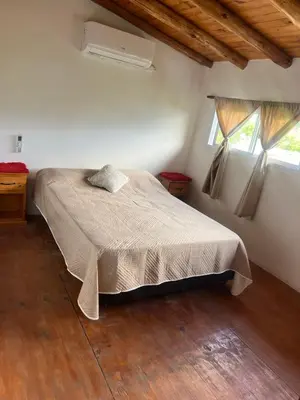a bedroom with a bed and two windows at Dpto Evelyn in Villa Cura Brochero