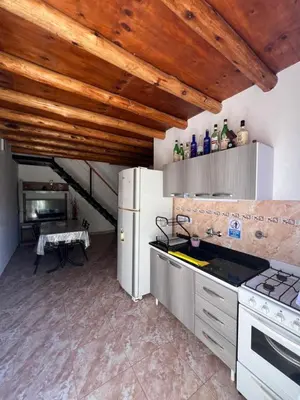 a kitchen with white appliances and a wooden ceiling at Dpto Evelyn in Villa Cura Brochero