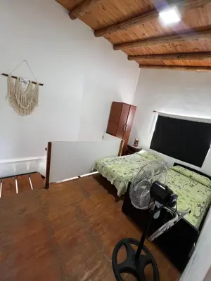 a bedroom with a bed and a camera on the floor at Dpto Evelyn in Villa Cura Brochero