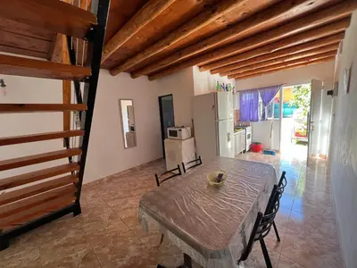 a dining room with a table and a kitchen at Dpto Evelyn in Villa Cura Brochero