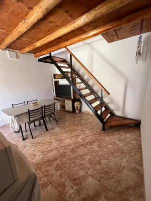 a room with a staircase and a table and chairs at Dpto Evelyn in Villa Cura Brochero