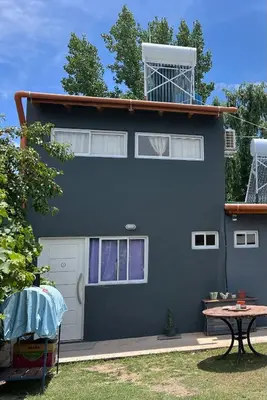 a blue house with a table in front of it at Dpto Evelyn in Villa Cura Brochero