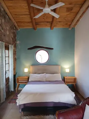 a bedroom with a bed and a ceiling fan at Vayu- en La Casa de Nanda in San Javier