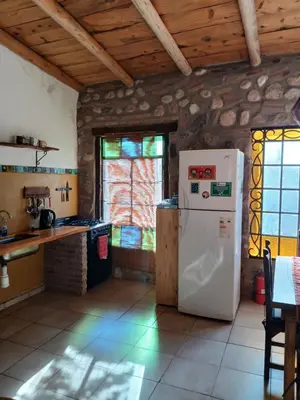 a kitchen with a refrigerator and a table and a window at Vayu- en La Casa de Nanda in San Javier