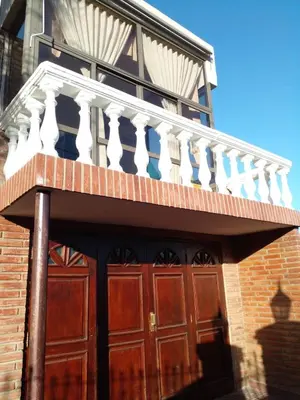 a wooden door with a balcony on a building at Casa Maravilla in Villa Carlos Paz