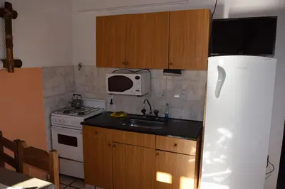 a kitchen with a refrigerator and a sink and a microwave at Complejo El Alto in Tanti