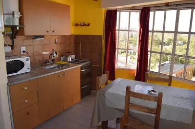 a kitchen with a table and a sink and a stove at Complejo El Alto in Tanti