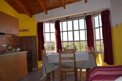 a kitchen with a table and some windows at Complejo El Alto in Tanti