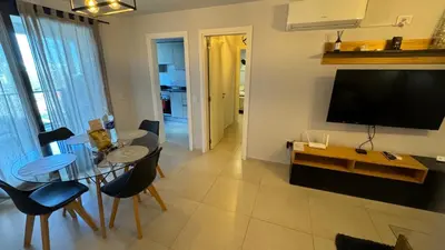 a living room with a television and a table and chairs at Guesthouse Park in Cordoba