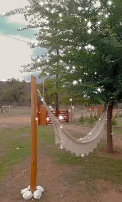 a hammock in a park next to a tree at El Rincon de las Marias in San Lorenzo