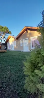 a house with a green yard in front of it at El Rincon de las Marias in San Lorenzo