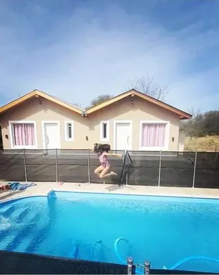 a girl sitting on the side of a swimming pool at El Rincon de las Marias in San Lorenzo