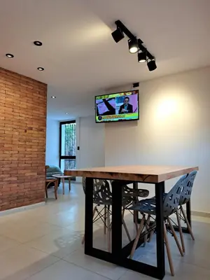 a dining room with a table and a tv on the wall at Moderno Departamento B° Urca P/ 4 Personas in Cordoba