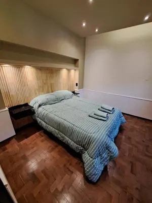 a bedroom with a bed with a blue blanket on it at Moderno Departamento B° Urca P/ 4 Personas in Cordoba