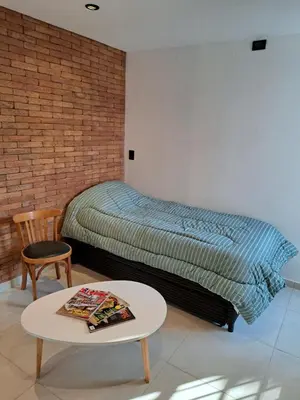 a bedroom with a bed and a table and a chair at Moderno Departamento B° Urca P/ 4 Personas in Cordoba