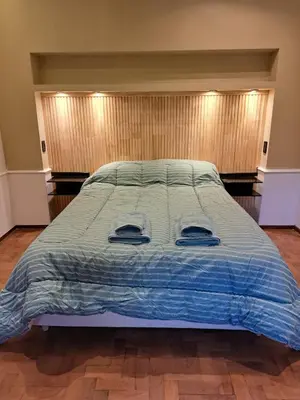 a large bed with a blue comforter in a bedroom at Moderno Departamento B° Urca P/ 4 Personas in Cordoba