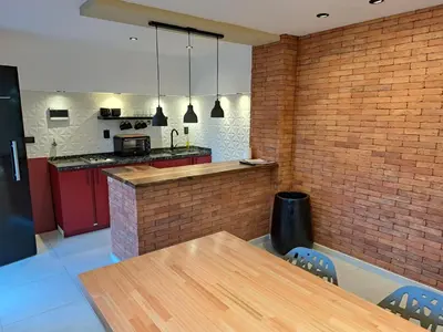 a kitchen with a wooden table and a brick wall at Moderno Departamento B° Urca P/ 4 Personas in Cordoba