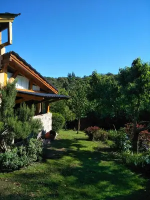 a person laying in the grass next to a house at Del Sol a la Montaña EcoLodge - Turismo Consciente in Potrero de Garay