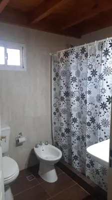 a bathroom with a sink and a toilet and a shower curtain at Dulce Refugio in Cortaderas