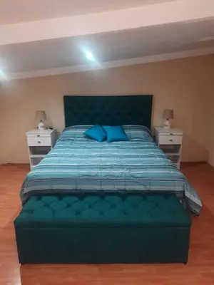 a bedroom with a green bed with two night stands at Dulce Refugio in Cortaderas