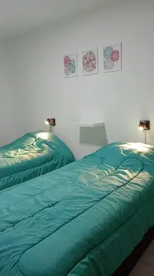a bedroom with two beds with green comforters on them at Esplendido Dpto 120 mts2 -PATIO/ASADOR/PILETA - Centro CBA in Cordoba