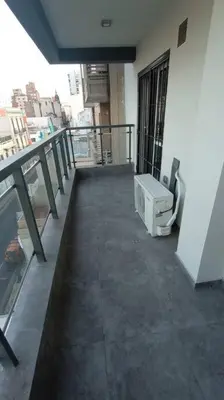 a balcony of a building with a television on it at Esplendido Dpto 120 mts2 -PATIO/ASADOR/PILETA - Centro CBA in Cordoba