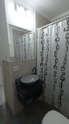 a bathroom with a sink and a shower curtain at Esplendido Dpto 120 mts2 -PATIO/ASADOR/PILETA - Centro CBA in Cordoba