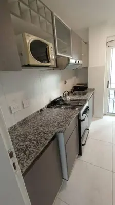 a kitchen with a counter top and a microwave at Esplendido Dpto 120 mts2 -PATIO/ASADOR/PILETA - Centro CBA in Cordoba