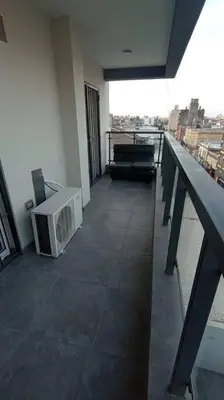 a balcony with a tv on the floor of a building at Esplendido Dpto 120 mts2 -PATIO/ASADOR/PILETA - Centro CBA in Cordoba