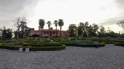a garden with a building with palm trees in the background at Tu lugar en Nueva Córdoba!A 50 mtros del Sanatorio Acongagua in Cordoba